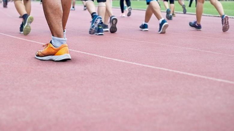 A group of people all walking on a track