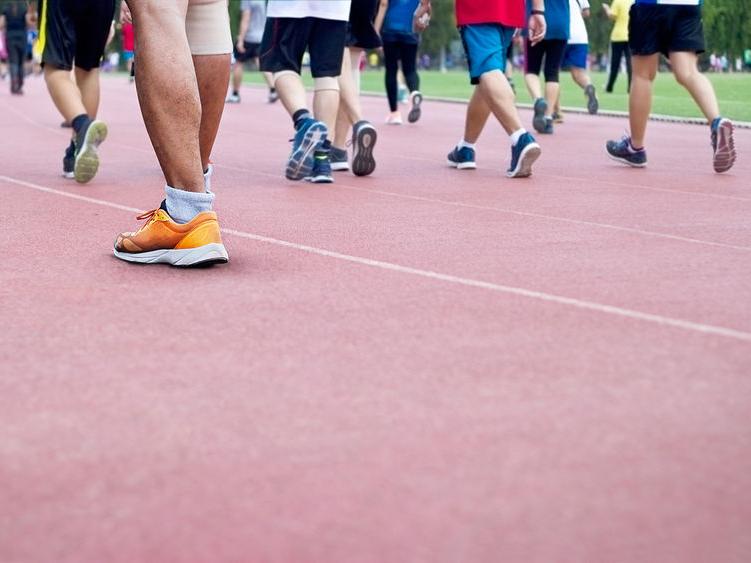 A group of people all walking on a track